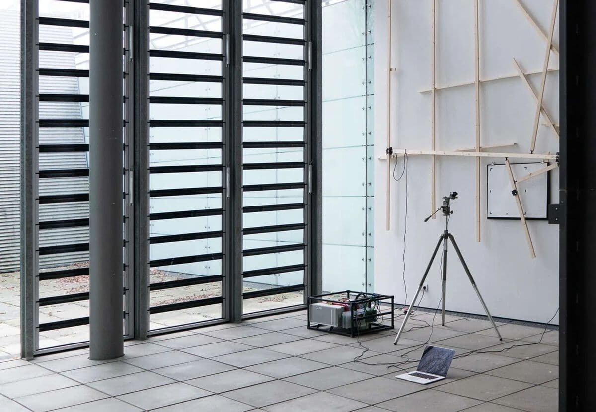 Close-up view of the wooden kinetic structure with integrated camera system